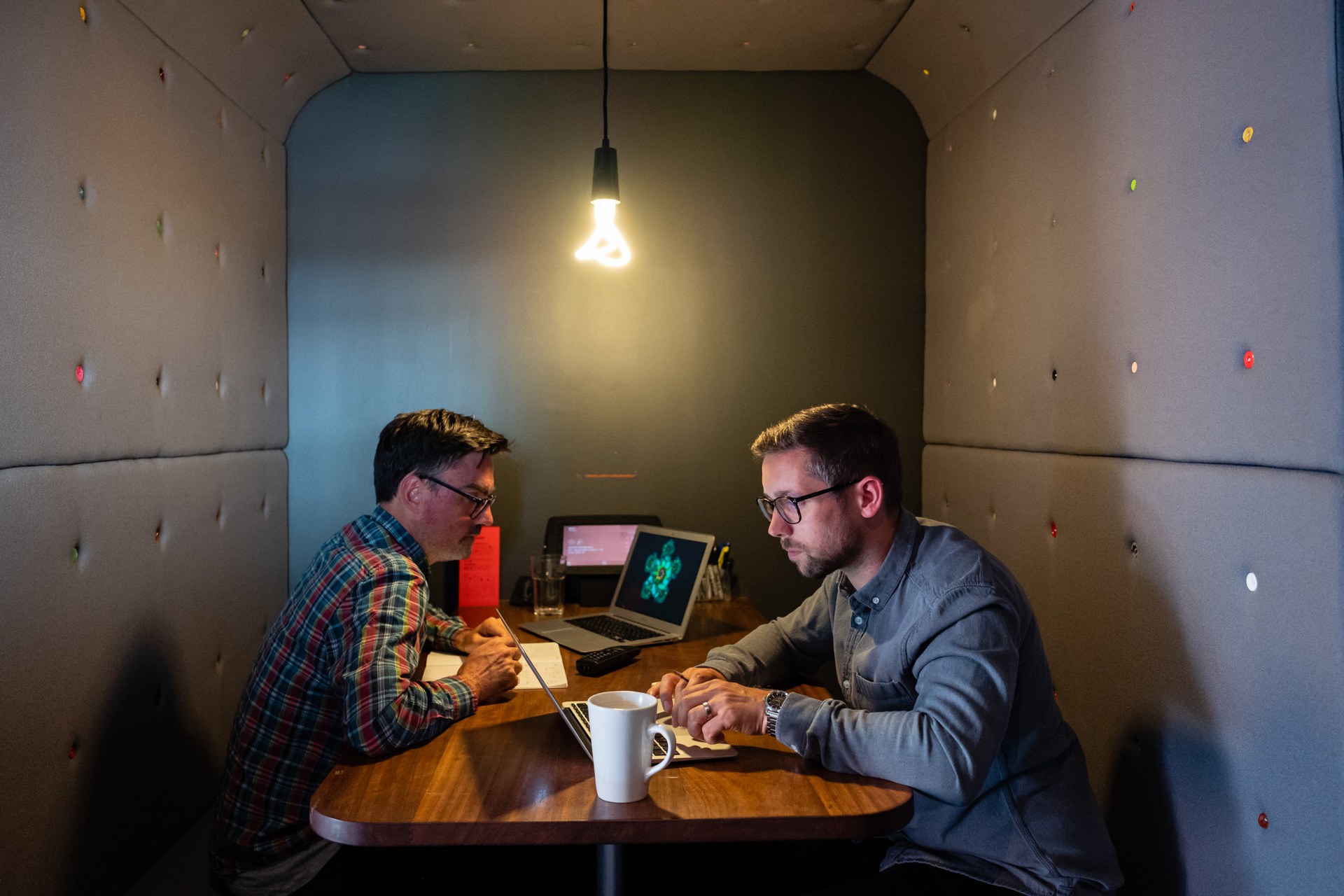 Uniform colleagues discussing work together in a meeting booth