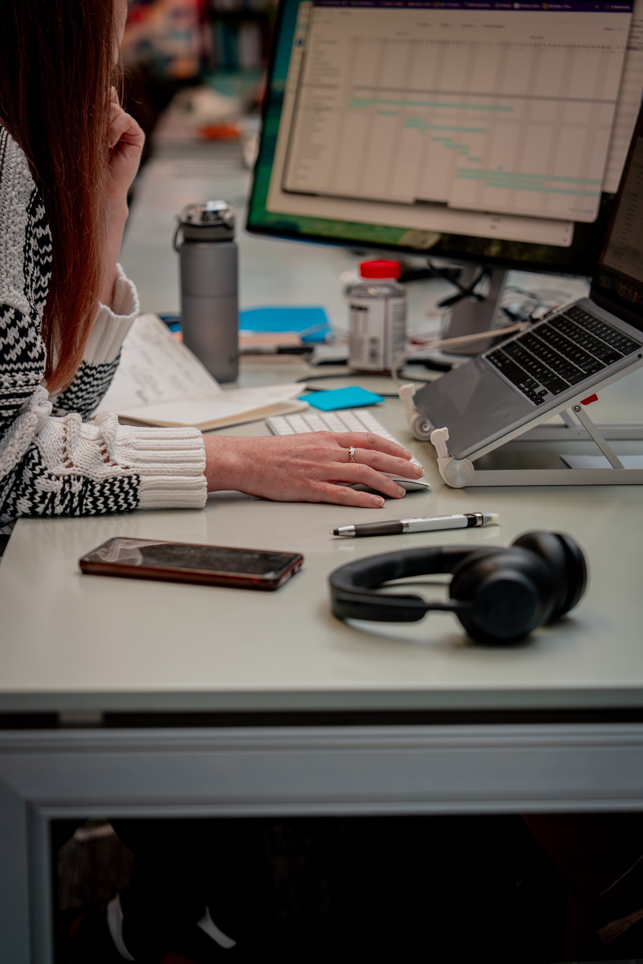 Uniform colleague working at a desk with a laptop and monitor