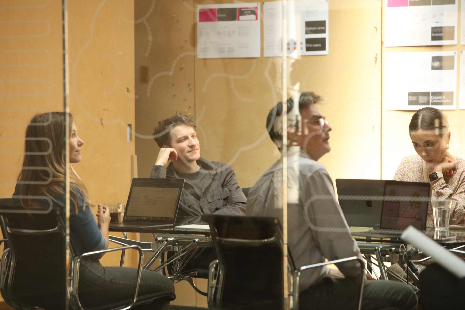 Uniform colleagues sharing ideas around laptops in a studio meeting