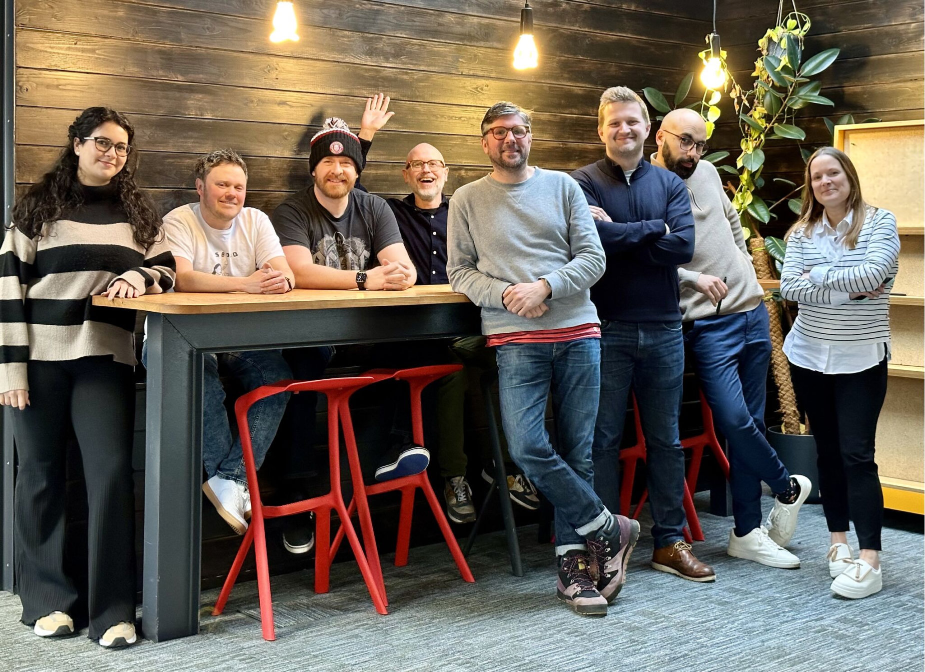 Uniform colleagues gathered around a high table in the studio