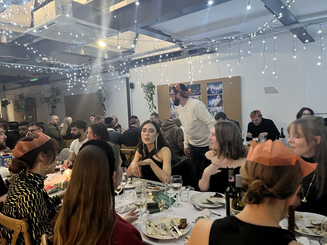 Uniform colleagues sharing a festive meal under string lights
